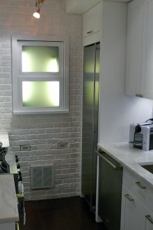 Εντοιχισμένο μεταλλικό ψυγείο σε μια μικρή κουζίνα