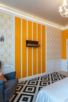 Uma combinação brilhante de papéis de parede diferentes com elementos laranja no quarto