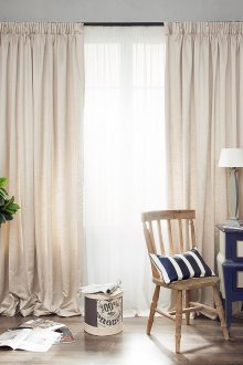 Μπεζ μακρύ κουρτίνες σε ένα ρουστίκ εσωτερικό σαλόνι