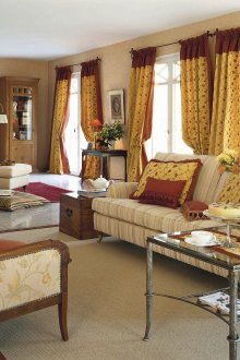 Κόκκινες και κίτρινες κουρτίνες στο εσωτερικό του σπιτιού στυλ εξοχής