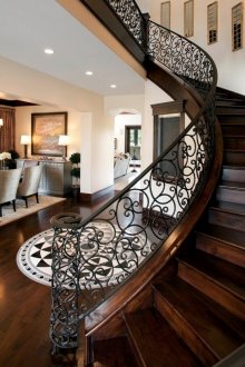 Περιστρέψτε ξύλινη σκάλα με κιγκλιδώματα από σφυρήλατο σίδηρο