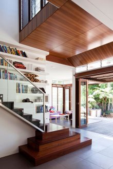 Ξύλινη καστανή σκάλα με κιγκλίδωμα από γυαλί.