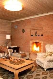 Ρουστίκ σαλόνι με τζάκι σε έναν τοίχο από τούβλα