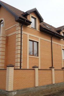 Αντιμετωπίζοντας το σπίτι και το φράχτη με ένα κίτρινο τούβλο