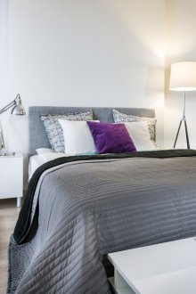 Γκρίζο υπνοδωμάτιο με μωβ τόνους.