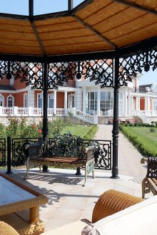 Arbor με στοιχεία από σφυρήλατο σίδερο και ψάθινα έπιπλα.