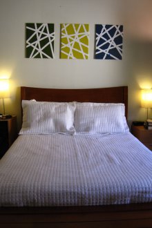 Πίνακες με γεωμετρικό σχέδιο πάνω από το κρεβάτι στην κρεβατοκάμαρα