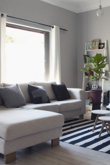 Κομψό ανοιχτό γκρι καναπέ στο σαλόνι του σκανδιναβικού στυλ