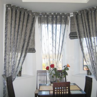 Κουρτίνες σε ροδέλες κατασκευασμένες από διαφανείς και πυκνές λωρίδες υφάσματος στην κουζίνα