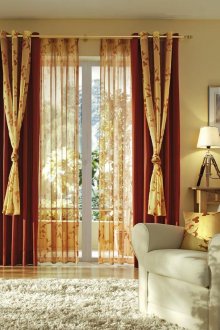 Κόκκινα, χρυσά κουρτίνες και τούλι στο σαλόνι.