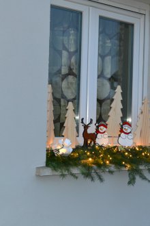 Διακόσμηση παραθύρων με ξύλινες φιγούρες για το νέο έτος