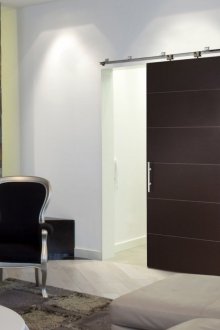 Μαύρη συρόμενη πόρτα σε φωτεινό δωμάτιο