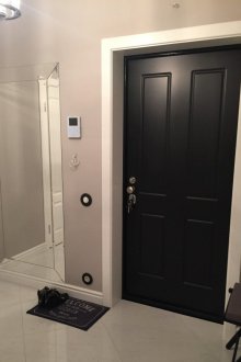 Μαύρη πόρτα εισόδου στο διάδρομο με γκρι ταπετσαρία