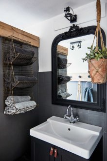 Μαύρο μπάνιο με διακόσμηση γύρω από τον καθρέφτη