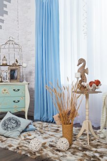 Μπλε κουρτίνες και μαξιλάρια στο σαλόνι