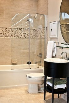 Μπεζ μπάνιο με σκούρα έπιπλα.