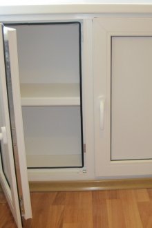 Πλαστικό ψυγείο κάτω από το παράθυρο