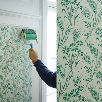 Ζωγραφίζοντας τους τοίχους με ένα κυλινδρικό κυλινδρικό σχήμα με τυρκουάζ χρώμα