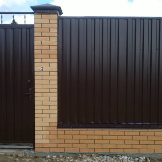 Φράχτη από μαύρο κυματοειδές χαρτόνι και τούβλο