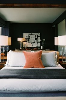 Μικρό υπνοδωμάτιο με σκοτεινούς τοίχους και μεγάλο καθρέφτη