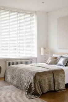 Κρεβάτι δίπλα στο παράθυρο στο υπνοδωμάτιο με το στυλ του μινιμαλισμού