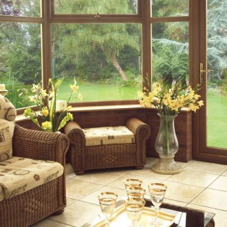 Καφέ ψάθινα έπιπλα σε μια τζάμια βεράντα