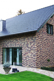 Πολύχρωμο τούβλο στην επένδυση ενός μικρού σπιτιού