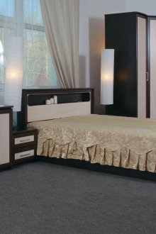 Μαύρο και μπεζ συρταριέρα και γωνιακό ντουλάπι στο εσωτερικό του υπνοδωματίου