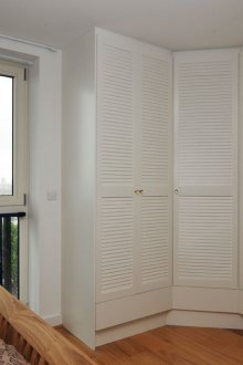 Λευκή ντουλάπα γωνιακής γωνίας στο υπνοδωμάτιο