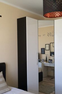 Ασπρόμαυρη γωνιακή ντουλάπα με καθρέφτη στο υπνοδωμάτιο