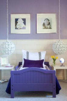 Λευκοί ιώδεις τοίχοι και μωβ κρεβάτι σε παιδικό υπνοδωμάτιο