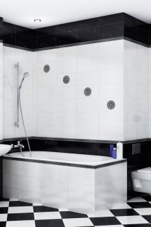 Τοποθέτηση με ρομβοειδές μαύρο και λευκό κεραμίδι στο μπάνιο